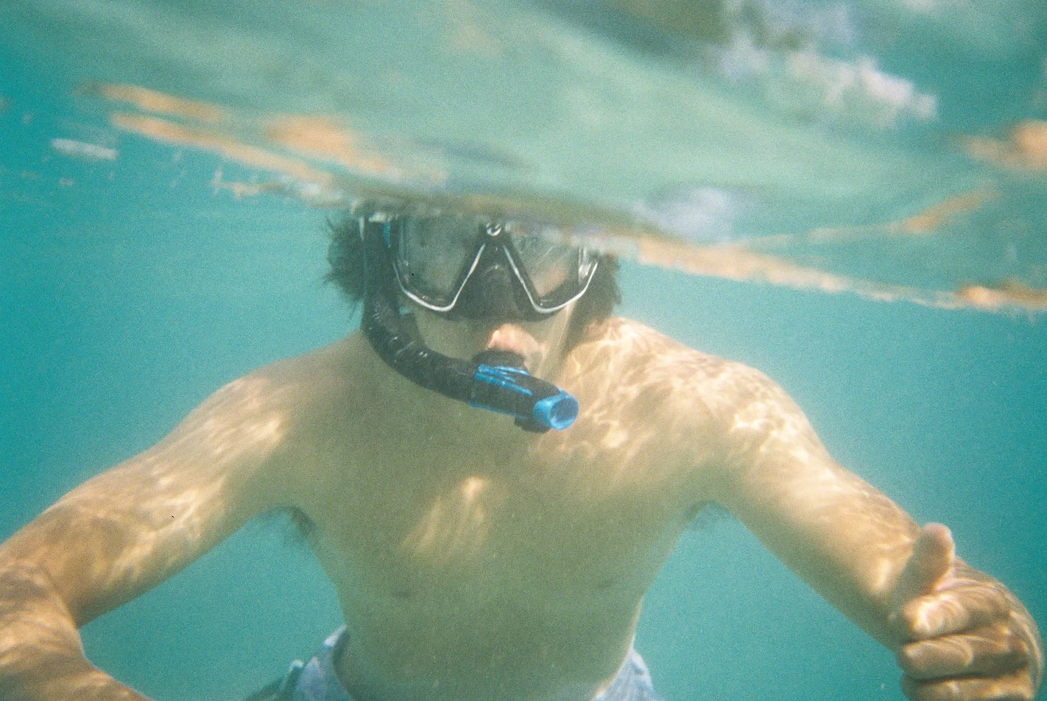 Bryan snorkeling underwater in clear turquoise water.