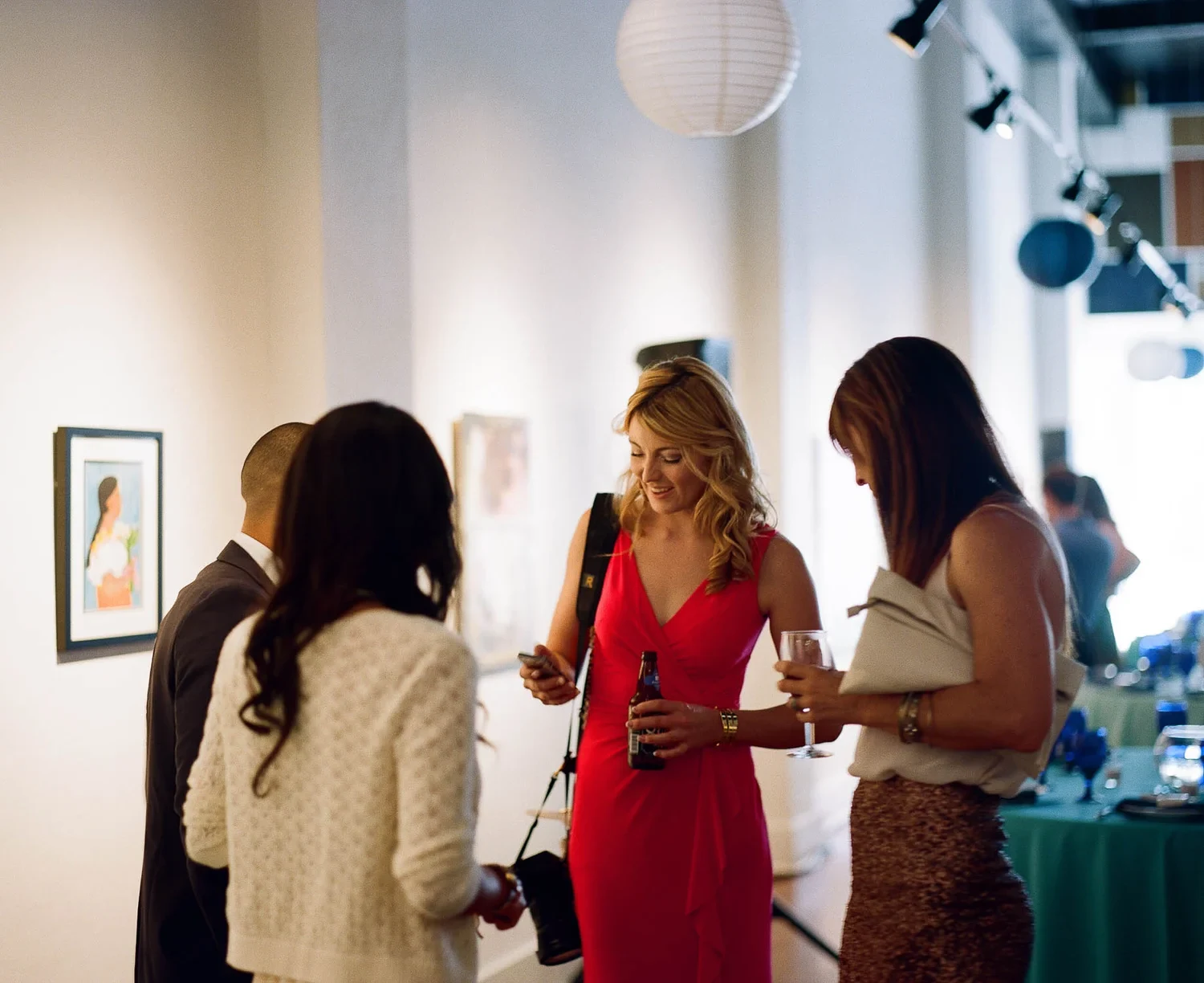 People talking in a bright room at an indoor gathering.
