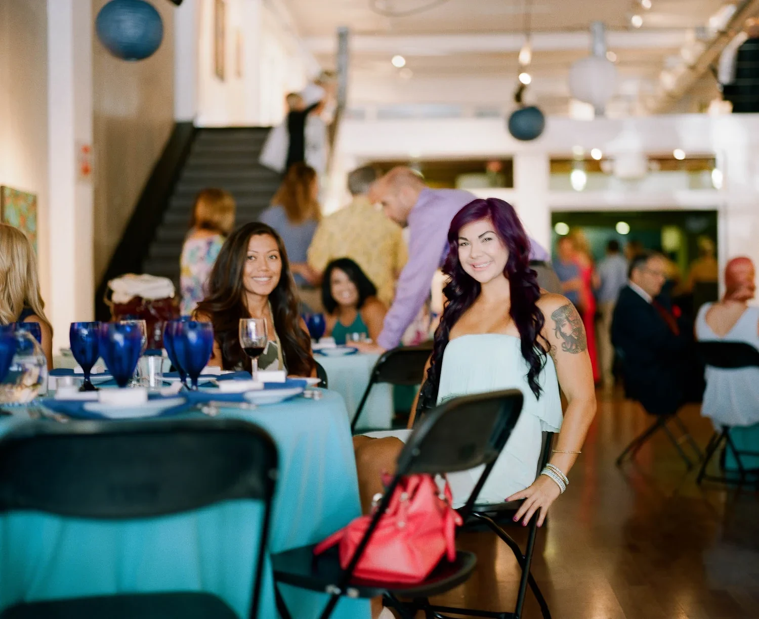 Woman seated at a restaurant table with other diners behind her.