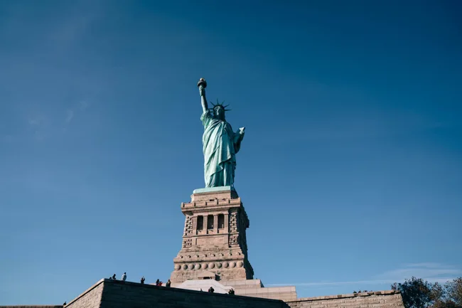 The Statue of Liberty beneath a blue sky.