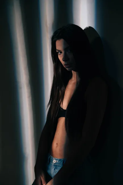 Side portrait of a model against dramatic strips of light.