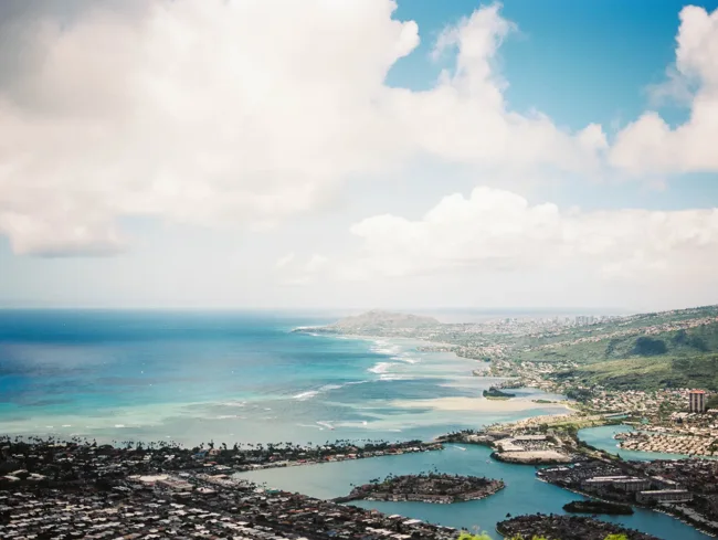 Elevated view of Oahu’s coast, reefs, and neighborhoods.