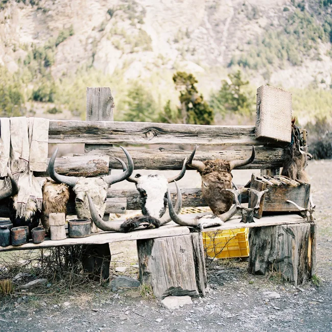 Weathered outdoor bench and rustic wooden objects beside stonework.