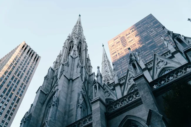 Gothic cathedral spires framed by modern skyscrapers.