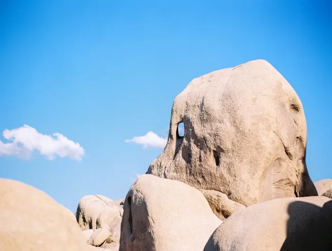 Large rounded boulder beneath a deep blue desert sky.