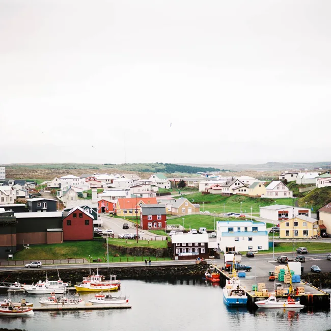 Colorful buildings and boats around a small Icelandic harbor.