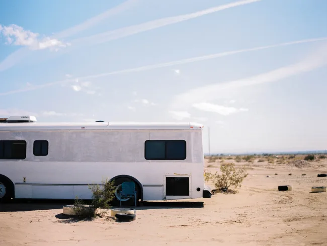 White trailer parked on open desert ground.