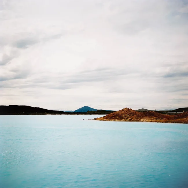 Pale turquoise water beneath a low, cloudy sky.