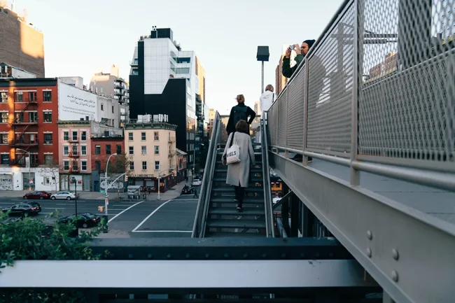 Pedestrian bridge and stairs above a Manhattan street.