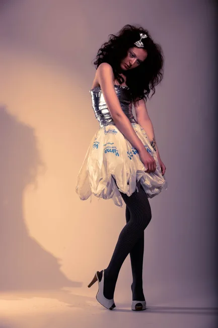 Full-length portrait of a model in a patterned skirt and black tights.